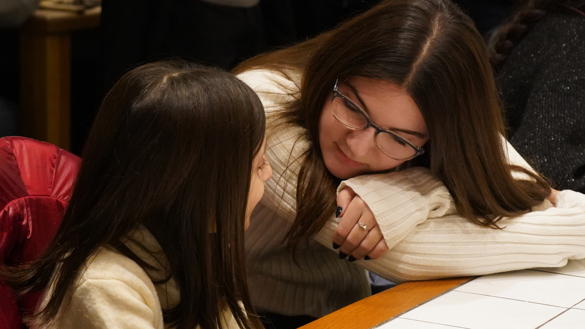 A teen teacher hugging a young student